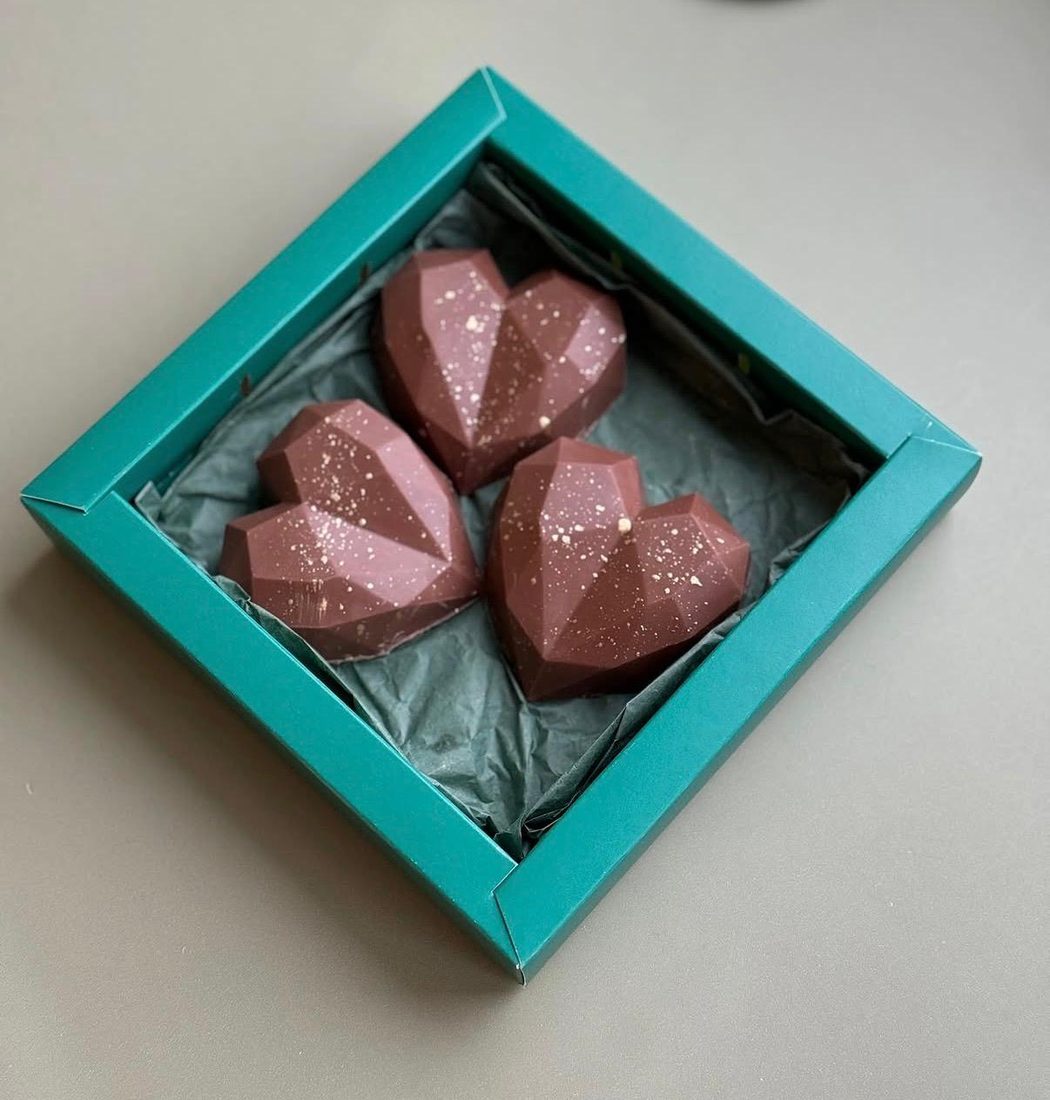 A teal gift box holding Big Bites in pink chocolate