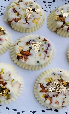 White rasmalai chocolate bites topped with pistachio, nuts and gold leaf