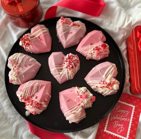 Pink strawberry chocolate hearts with a white drizzle