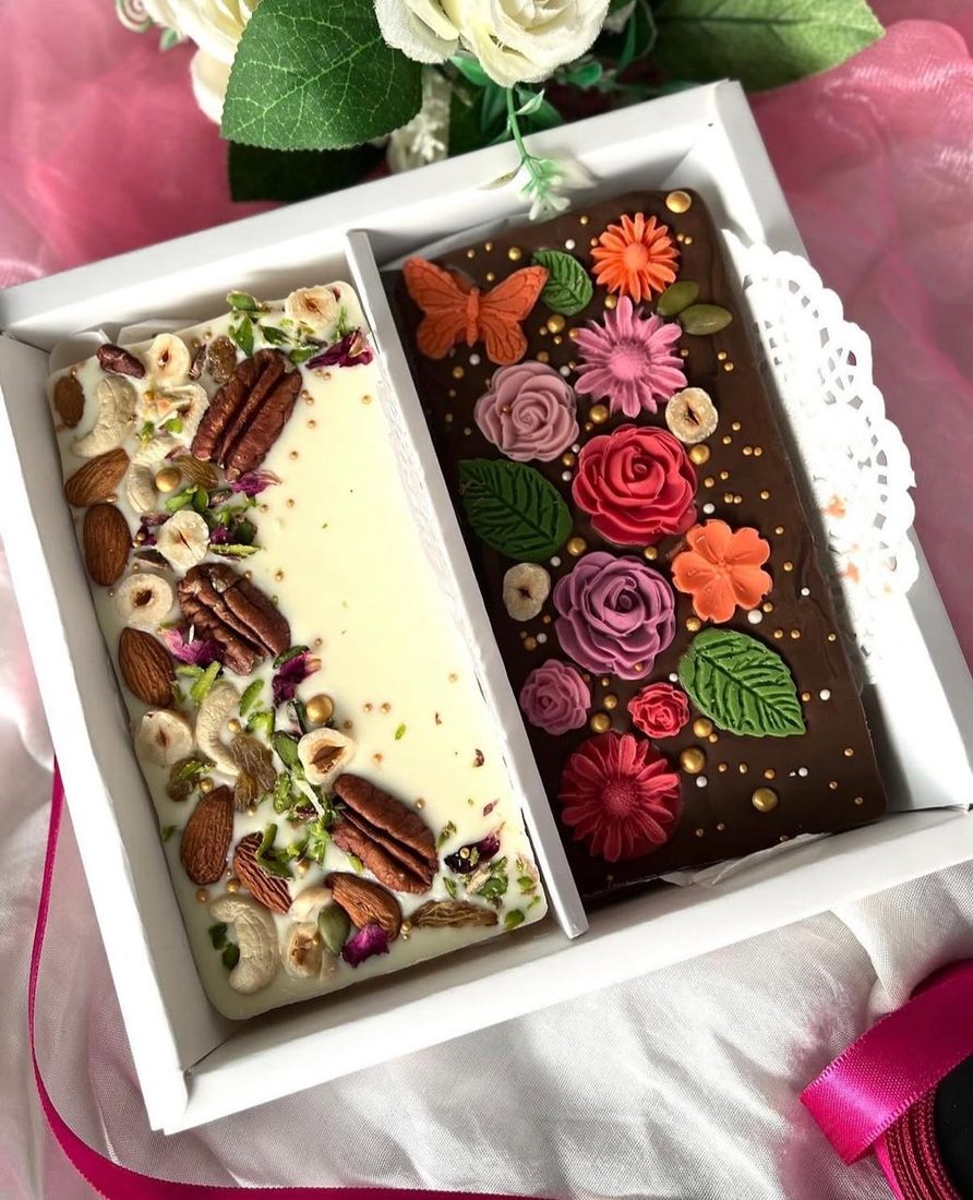 A pair of customised bars in a gift box, one white and one dark