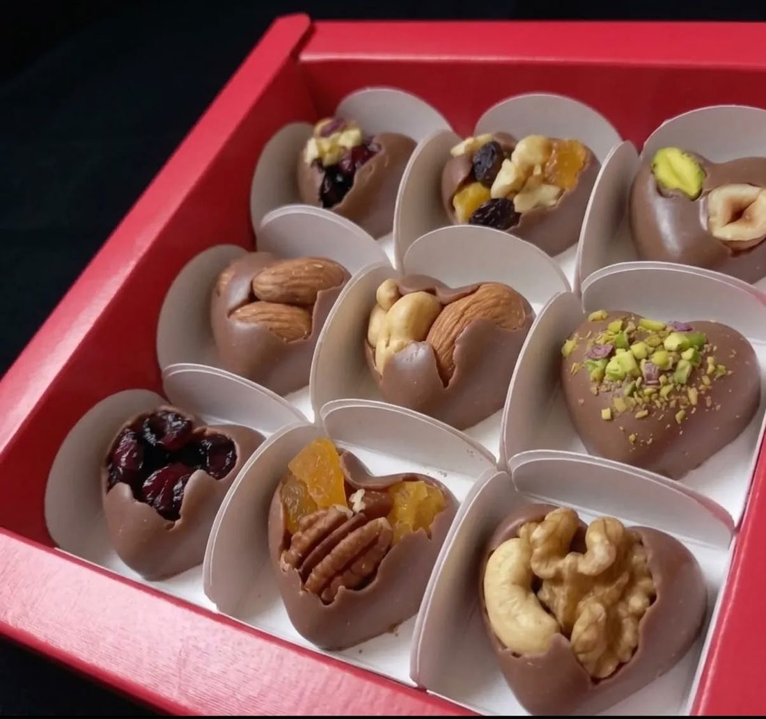 A red gift box of customised bites topped with whole nuts