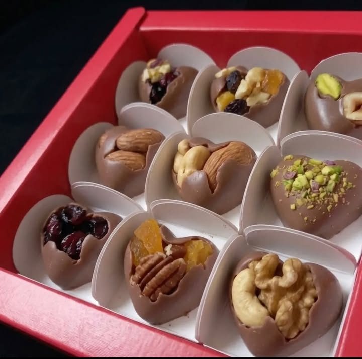A box of chocolates topped with cashew, almond, pistachio and walnut